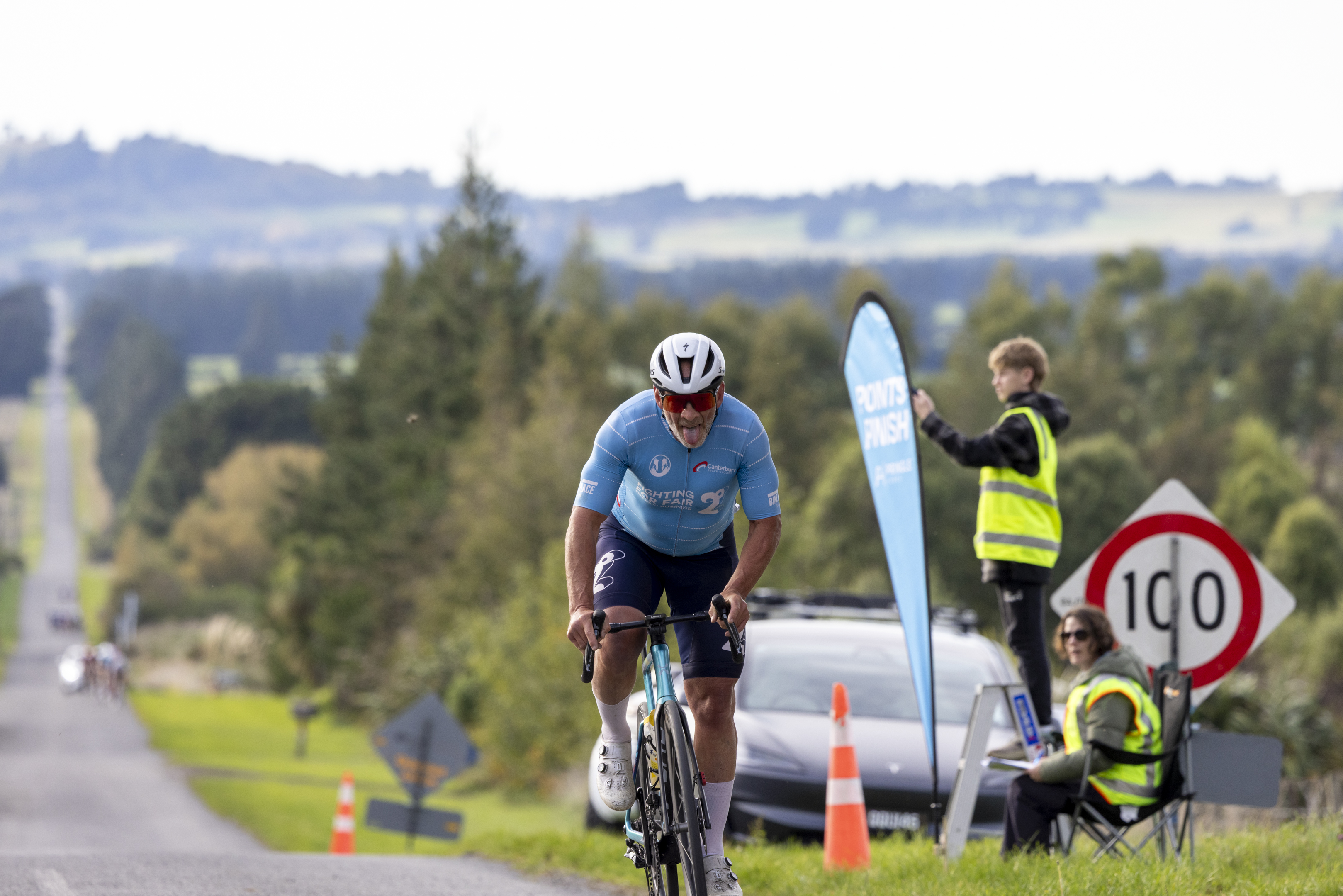 Andy Beale sticking his tongue out while cycling towards the camera