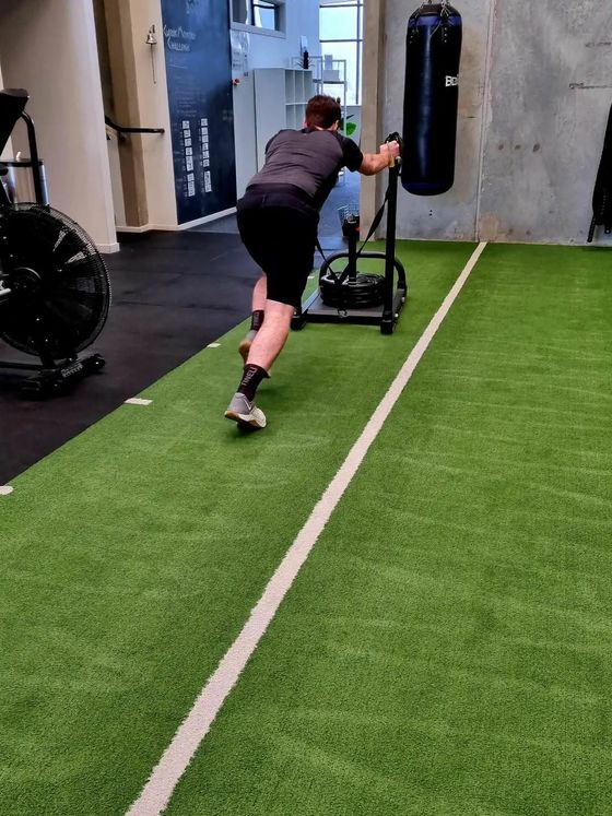 Training with a resistance sled on the gym turf